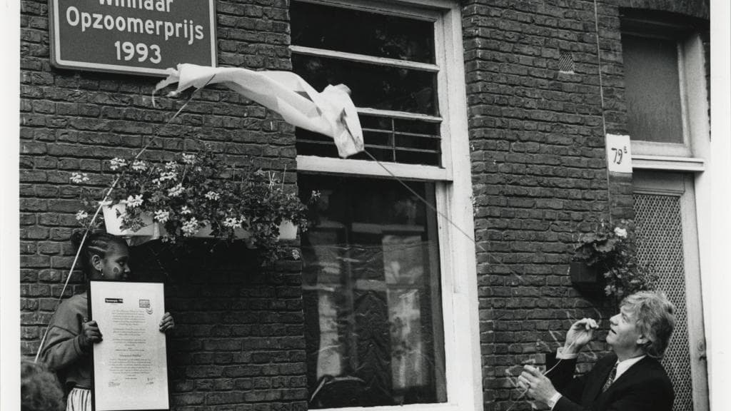 Zwart-witfoto van de onthulling van een straatnaambord met daarop: Winnaar Opzoomerprijs 1993.