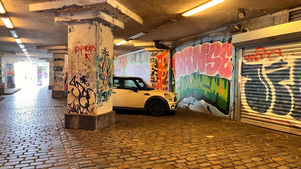 Tunneltje onder Boompjes met graffiti en een auto